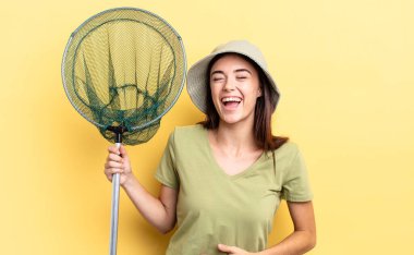 Genç İspanyol kadın komik bir balık ağı konseptine yüksek sesle gülüyor.