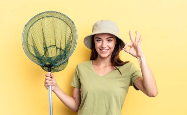 Genç İspanyol kadın kendini mutlu hissediyor. Onaylıyor. Jest balığı ağı konseptiyle.