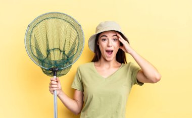 Genç İspanyol kadın mutlu görünüyor, şaşkın ve şaşkın balık ağı konsepti