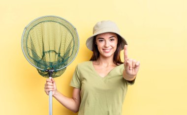 Genç İspanyol kadın gülümsüyor ve arkadaş canlısı görünüyor, bir numaralı balık ağı konseptini gösteriyor