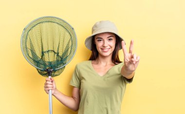 Genç İspanyol kadın gülümsüyor ve arkadaş canlısı görünüyor. İki numaralı balık ağı konseptini gösteriyor.