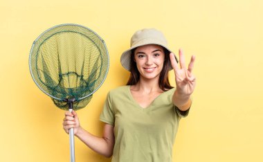 Genç İspanyol kadın gülümsüyor ve arkadaş canlısı görünüyor. Üç numaralı balık ağı konseptini gösteriyor.