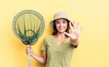 Genç İspanyol kadın gülümsüyor ve arkadaş canlısı görünüyor. Beş numaralı balık ağı konseptini gösteriyor.