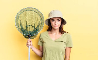 Genç İspanyol kadın üzgün, üzgün ya da kızgın hissediyor ve balık ağı kavramına bakıyor.