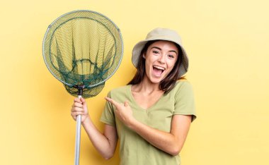 Genç İspanyol kadın balık ağı kavramına işaret ederek heyecanlı ve şaşırmış görünüyor.