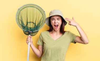 Genç İspanyol kadın mutsuz ve stresli görünüyor, intihar jesti silah işareti balık ağı konsepti yapıyor