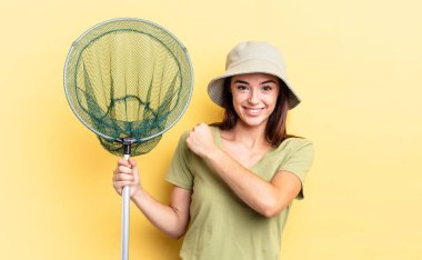 Genç İspanyol kadın mutlu ve zorluklarla yüzleşiyor veya balık ağı kavramını kutluyor