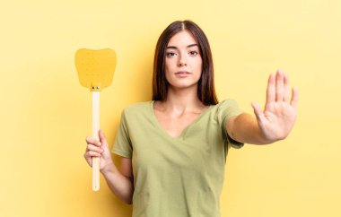 Genç İspanyol kadın ciddi görünüyor. Avuç içini gösteriyor. Durdurma hareketi yapıyor. Öldürme konsepti