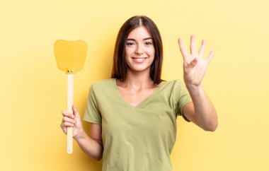 Genç İspanyol kadın gülümsüyor ve arkadaş canlısı görünüyor, dört numarayı gösteriyor. Öldürme konsepti