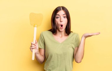 Genç İspanyol kadın şaşırmış ve şok olmuş görünüyor. Çenesi düşmüş ve elinde bir nesne tutuyor. Öldürme konsepti