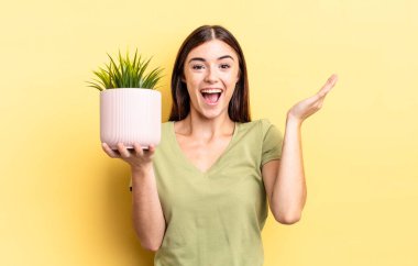 Genç İspanyol kadın kendini mutlu hissediyor ve inanılmaz bir şeye hayret ediyor. bitki otu konsepti