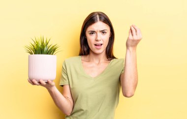 Genç İspanyol kadın kapiş ya da para hareketi yapıyor, sana ödemeni söylüyor. bitki otu konsepti