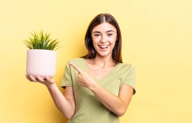 Genç İspanyol kadın heyecanlı ve şaşırmış görünüyor. bitki otu konsepti