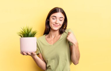 Genç İspanyol kadın kibirli, başarılı, pozitif ve gururlu görünüyor. bitki otu konsepti