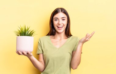 Genç İspanyol kadın kendini mutlu hissediyor, bir çözüm ya da fikir bulduğuna şaşırıyor. bitki otu konsepti