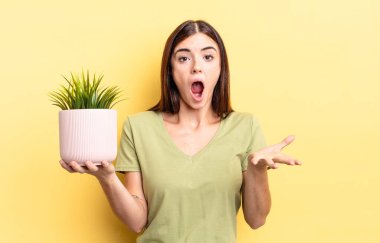 Genç İspanyol kadın şok olmuş ve şaşırmış hissediyor. bitki otu konsepti