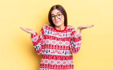 Genç İspanyol kadın şaşkın, şaşkın ve şüpheci hissediyor. Chistmas ve yeni yıl konsepti