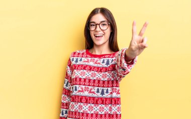 Genç İspanyol kadın gülümsüyor ve mutlu görünüyor, zafer ya da barış işareti yapıyor. Chistmas ve yeni yıl konsepti