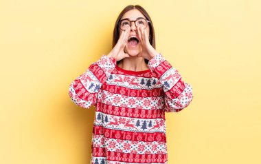 Genç İspanyol kadın kendini mutlu hissediyor, elleri ağzının kenarında bağırıyor. Chistmas ve yeni yıl konsepti