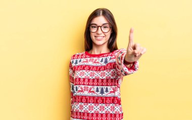 Genç İspanyol kadın gururla gülümsüyor ve kendinden emin bir numara oluyor. Chistmas ve yeni yıl konsepti