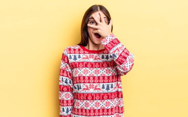 Genç İspanyol bir kadın şok olmuş, korkmuş ya da korkmuş görünüyor. Yüzü elle kapatılmış. Chistmas ve yeni yıl konsepti