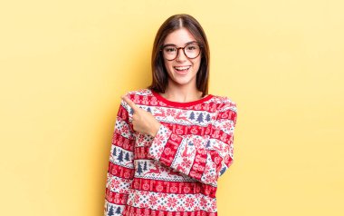 Genç İspanyol kadın neşeyle gülümsüyor, mutlu hissediyor ve bir tarafı işaret ediyor. Chistmas ve yeni yıl konsepti