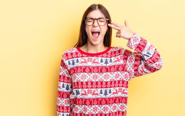 Genç İspanyol kadın mutsuz ve stresli görünüyor, intihar jesti silah işareti yapıyor. Chistmas ve yeni yıl konsepti