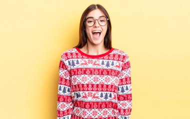 Genç İspanyol kadın mutlu ve hoş bir şekilde şaşırmış görünüyor. Chistmas ve yeni yıl konsepti