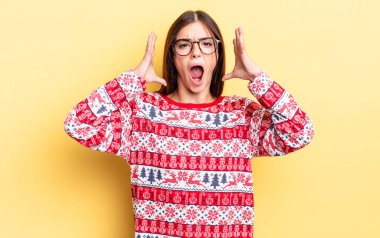 Genç İspanyol kadın ellerini havaya kaldırarak çığlık atıyor. Chistmas ve yeni yıl konsepti