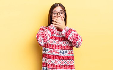 Genç İspanyol kadın şok olmuş ellerle ağzını kapatıyor. Chistmas ve yeni yıl konsepti