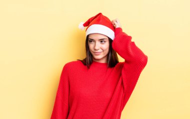 Genç İspanyol kadın mutlu bir şekilde gülümsüyor ve hayal kuruyor ya da şüphe ediyor. Chistmas ve yeni yıl konsepti