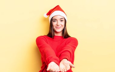 Genç İspanyol kadın mutlu bir şekilde gülümsüyor ve bir konsept sunuyor. Chistmas ve yeni yıl konsepti