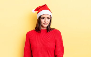 Genç İspanyol kadın üzgün, üzgün ya da kızgın hissediyor ve yana bakıyor. Chistmas ve yeni yıl konsepti