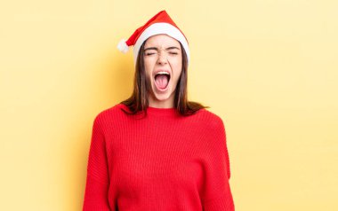 Genç İspanyol kadın agresif bir şekilde bağırıyor, çok kızgın görünüyor. Chistmas ve yeni yıl konsepti