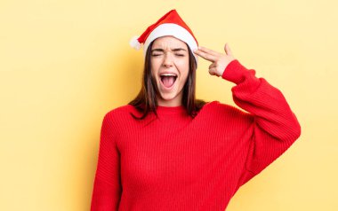 Genç İspanyol kadın mutsuz ve stresli görünüyor, intihar jesti silah işareti yapıyor. Chistmas ve yeni yıl konsepti