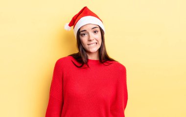 Genç İspanyol kadın şaşkın ve şaşkın görünüyor. Chistmas ve yeni yıl konsepti