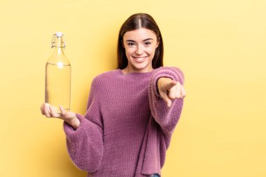 Genç İspanyol kadın kamerayı göstererek seni seçiyor. su şişesi kavramı