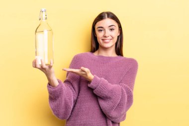 Genç İspanyol kadın neşeyle gülümsüyor, mutlu hissediyor ve bir konsept gösteriyor. su şişesi kavramı