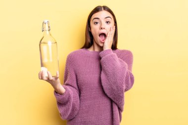 Genç İspanyol kadın şok olmuş ve korkmuş hissediyor. su şişesi kavramı
