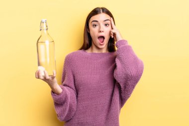 Genç İspanyol kadın şaşırmış görünüyor, yeni bir düşünce, fikir ya da konsept keşfediyor. su şişesi kavramı