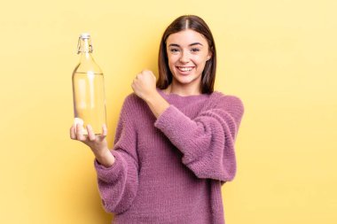 Genç İspanyol kadın kendini mutlu hissediyor ve bir meydan okumayla yüzleşiyor ya da kutluyor. su şişesi kavramı