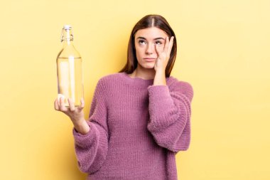 Genç İspanyol bir kadın bıkkın, hayal kırıklığına uğramış ve yorucu bir günün ardından uykulu hissediyor. su şişesi kavramı