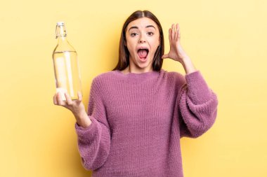 Genç İspanyol kadın ellerini havaya kaldırarak çığlık atıyor. su şişesi kavramı