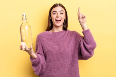 Genç İspanyol kadın bir fikri fark ettikten sonra mutlu ve heyecanlı bir dahi gibi hissediyor. su şişesi kavramı