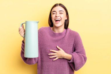 Genç İspanyol kadın komik bir şakaya yüksek sesle gülüyor. Kahve termosu kavramı