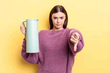 Latin kökenli genç bir kadın kızmış, baş parmağını kaldırmış. Kahve termosu kavramı