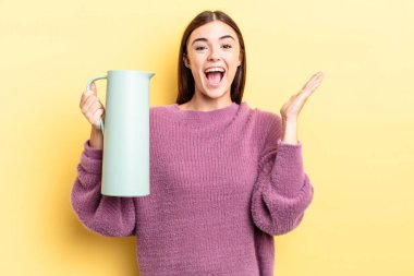 Genç İspanyol kadın kendini mutlu hissediyor ve inanılmaz bir şeye hayret ediyor. Kahve termosu kavramı