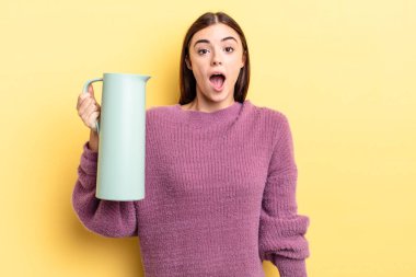 Genç İspanyol kadın çok şaşırmış ya da şok olmuş görünüyor. Kahve termosu kavramı