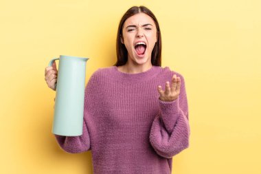 Genç İspanyol kadın kızgın, sinirli ve hayal kırıklığına uğramış görünüyor. Kahve termosu kavramı