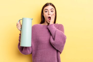 Genç İspanyol kadın şok olmuş ve korkmuş hissediyor. Kahve termosu kavramı